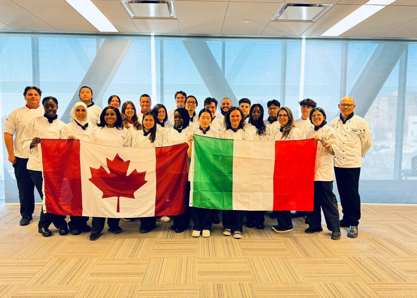 Humber culinary students in chef whites holding Canadian and Italian flags