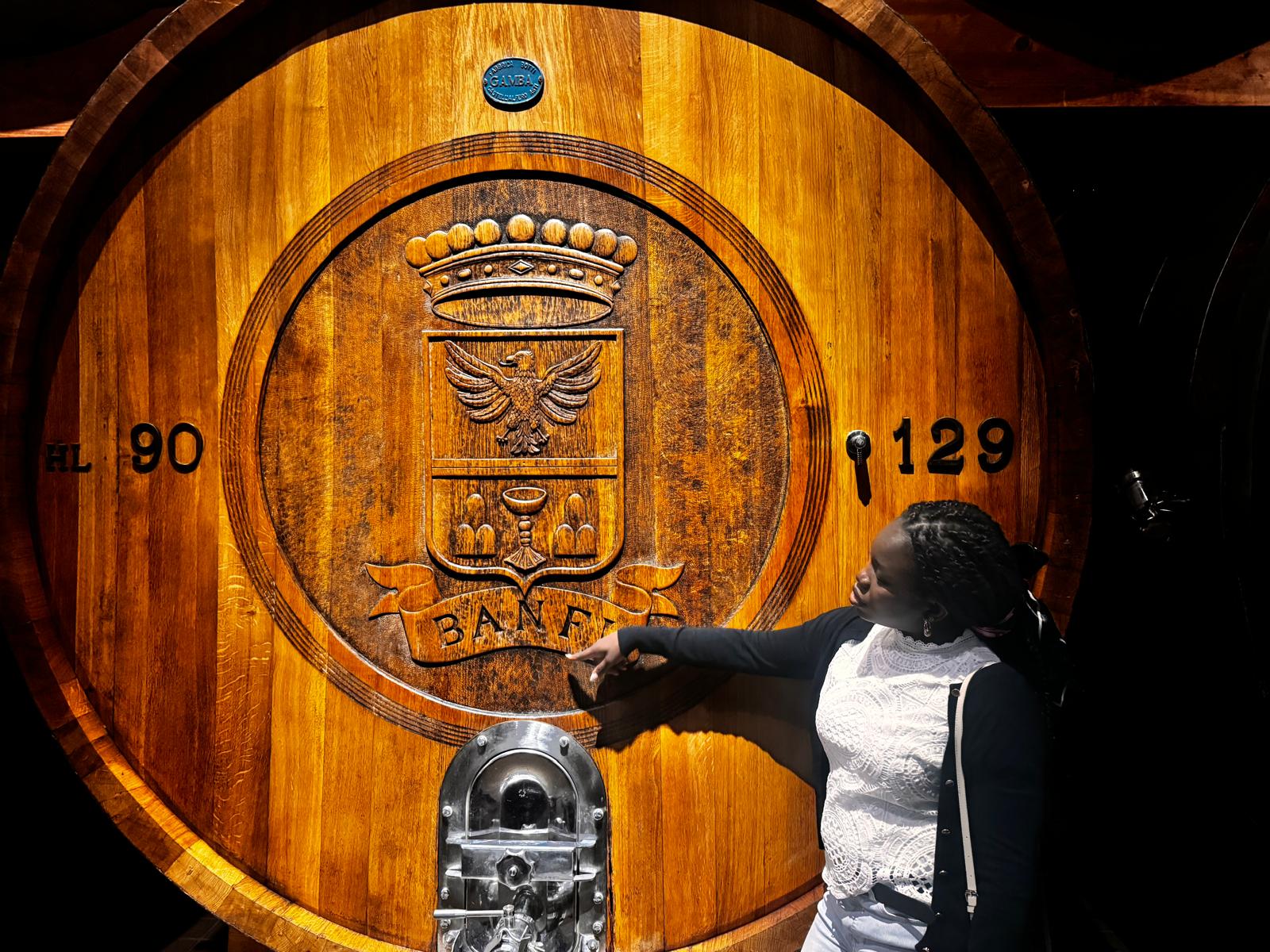 Temi at a large carved Banfi wine barrel in Tuscany