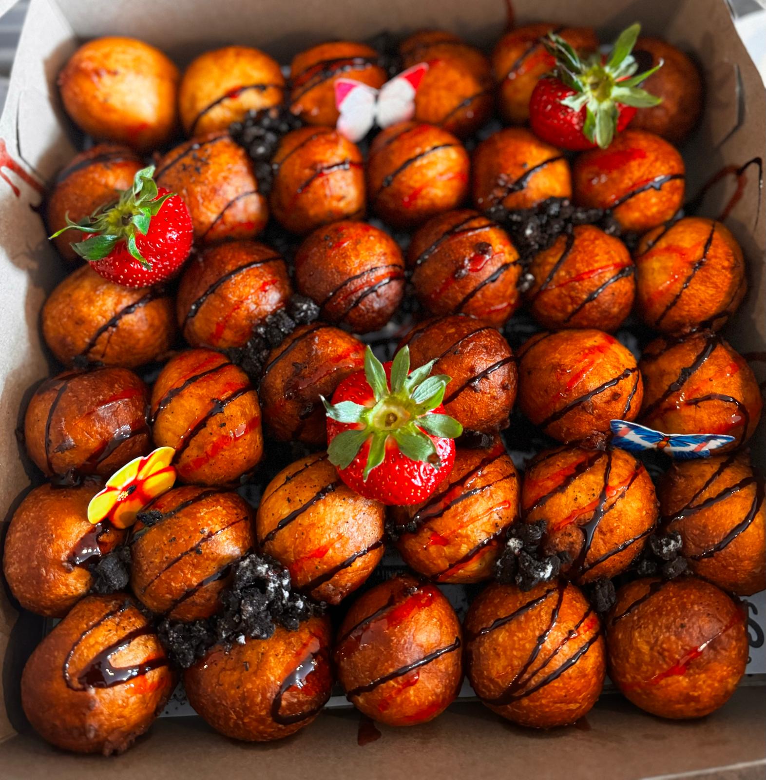 Gourmet puff puff with chocolate drizzle and fresh strawberries