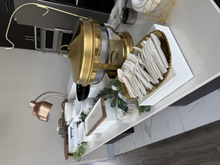 Catering table setup with gold chafing dish and cutlery before service