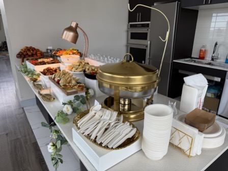 Catering buffet spread with gold chafing dish and copper lamps