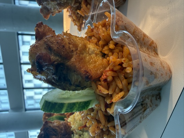Jollof rice with chicken and cucumber garnish
