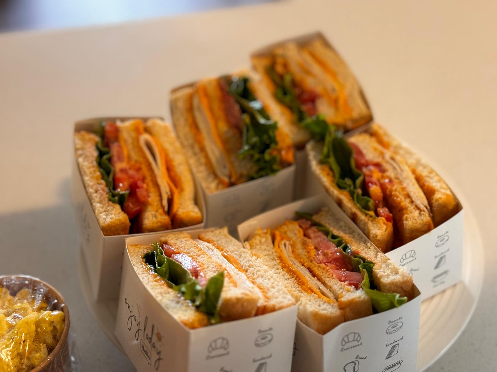 Stacked club sandwiches in individual boxes
